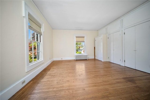33 Kay St, Newport, RI 02840 - unfurnished bedroom featuring radiator heating unit, light wood finished floors, and two closets