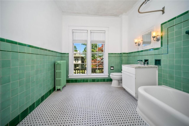 33 Kay St, Newport, RI 02840 - full bath with radiator, tile walls, vanity, a freestanding tub, and wainscoting