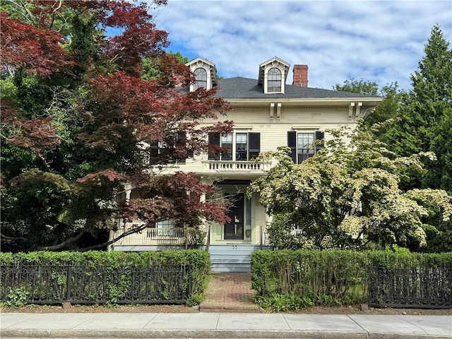 33 Kay St, Newport, RI 02840 - view of front of property with a fenced front yard, a chimney, and a balcony