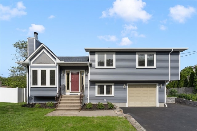 151 Mohawk Trl, Cranston, RI 02921 - tri-level home with entry steps, asphalt driveway, a garage, and a chimney