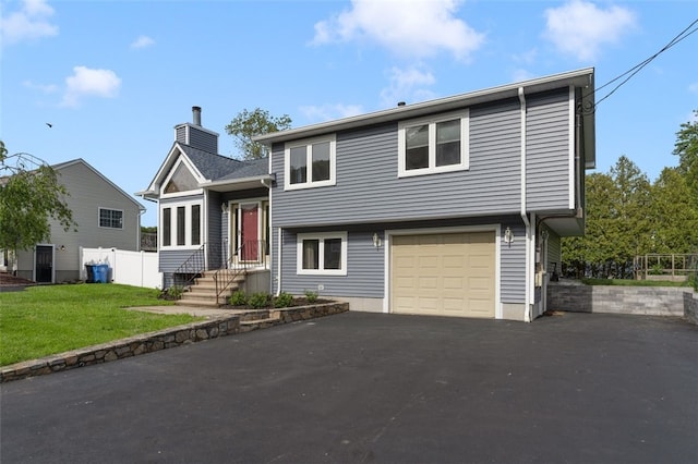 151 Mohawk Trl, Cranston, RI 02921 - split level home featuring a chimney, driveway, and an attached garage