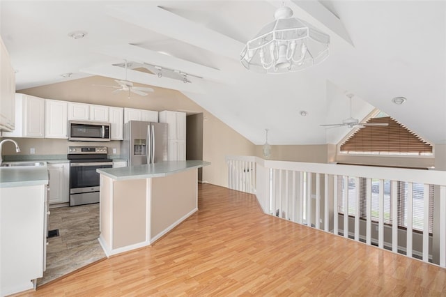 151 Mohawk Trl, Cranston, RI 02921 - kitchen with stainless steel appliances, a ceiling fan, lofted ceiling, light wood-style flooring, and white cabinetry