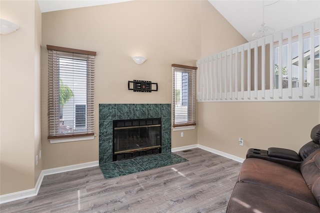 151 Mohawk Trl, Cranston, RI 02921 - living area featuring wood finished floors, a tile fireplace, and high vaulted ceiling