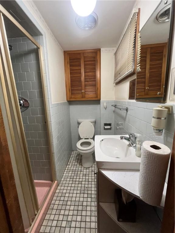 16 Winthrop St, Cranston, RI 02910 - bathroom featuring tile walls, a stall shower, tile patterned flooring, vanity, and a wainscoted wall