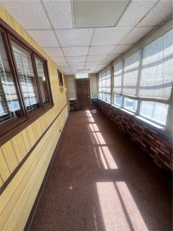16 Winthrop St, Cranston, RI 02910 - hallway featuring dark carpet, a drop ceiling, and brick wall