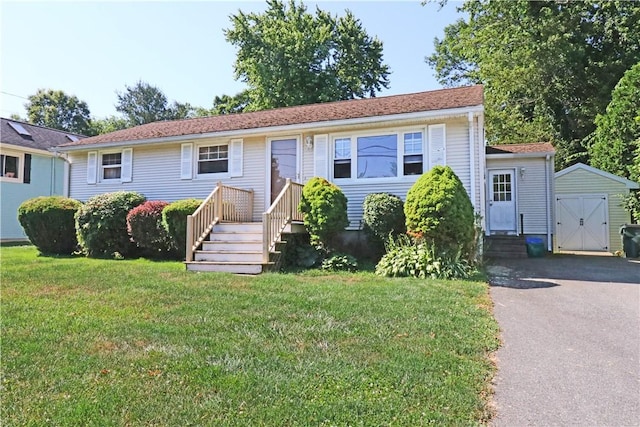 27 Louise Dr, Tiverton, RI 02878 - view of front of home featuring a front yard, asphalt driveway, a storage unit, and entry steps