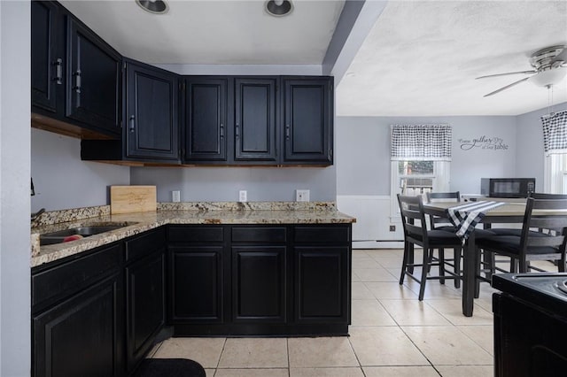 40 W Cole St, Pawtucket, RI 02861 - kitchen with black appliances, plenty of natural light, dark cabinetry, and wainscoting