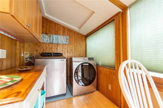 130 Knowlesway Ext, Narragansett, RI 02882 - washroom featuring cabinet space, wooden walls, light wood-style flooring, independent washer and dryer, and healthy amount of natural light