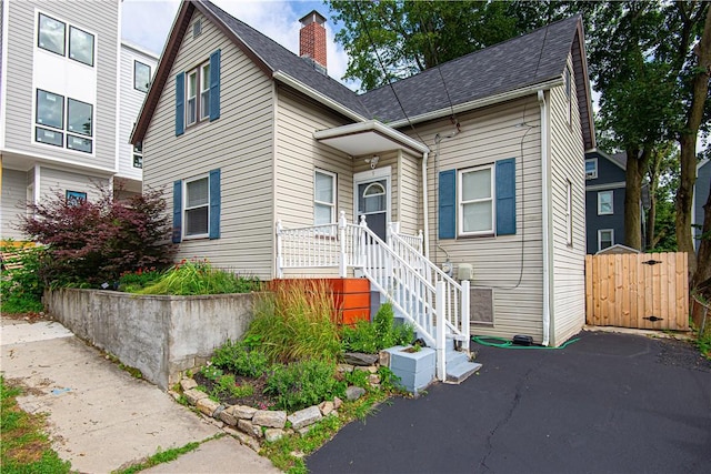 9 Locust St, Providence, RI 02906 - view of front facade featuring a chimney and a shingled roof