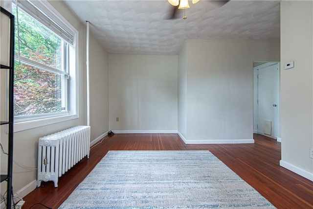 9 Locust St, Providence, RI 02906 - empty room with radiator heating unit, wood finished floors, ceiling fan, and a textured ceiling