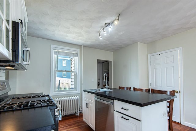 9 Locust St, Providence, RI 02906 - kitchen with stainless steel dishwasher, radiator heating unit, range with gas cooktop, and dark countertops