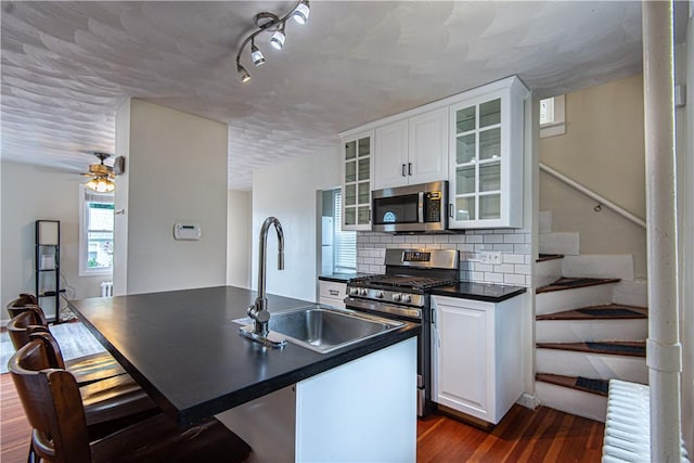 9 Locust St, Providence, RI 02906 - kitchen featuring appliances with stainless steel finishes, dark countertops, dark wood-style flooring, and white cabinets