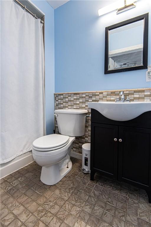 9 Locust St, Providence, RI 02906 - full bath featuring vanity, tile walls, curtained shower, and a wainscoted wall