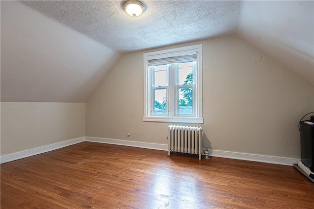 9 Locust St, Providence, RI 02906 - bonus room with radiator heating unit, wood finished floors, vaulted ceiling, and a textured ceiling