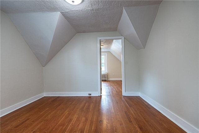 9 Locust St, Providence, RI 02906 - bonus room with wood finished floors, radiator, lofted ceiling, and a textured ceiling