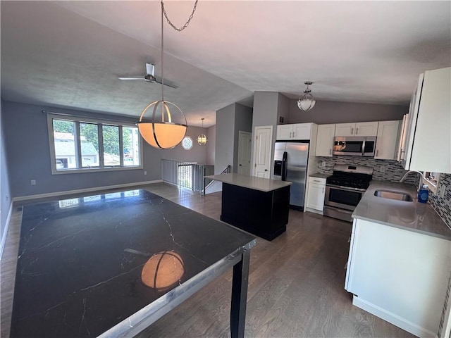 27 Brook St, West Warwick, RI 02893 - kitchen featuring appliances with stainless steel finishes, lofted ceiling, dark wood-type flooring, a kitchen island, and white cabinets
