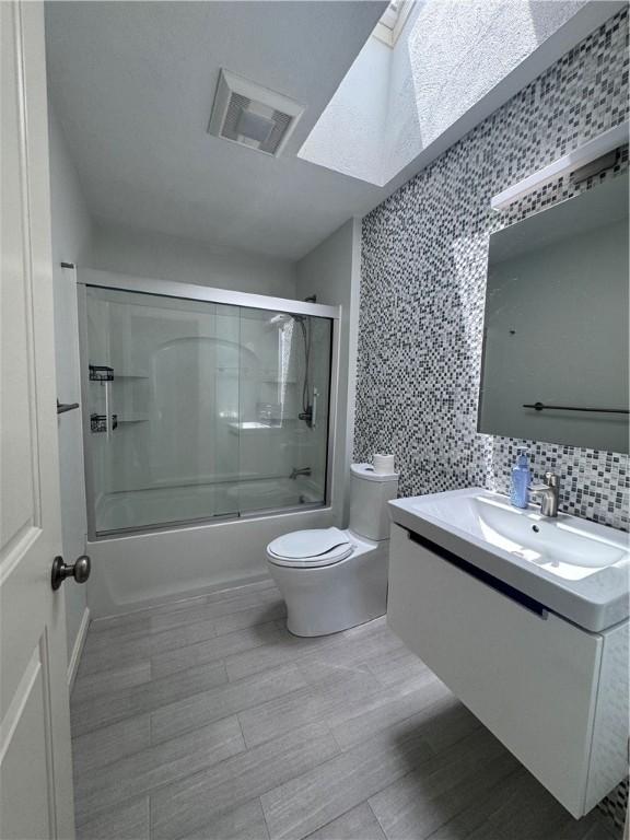 27 Brook St, West Warwick, RI 02893 - bathroom featuring vanity, bath / shower combo with glass door, and a skylight