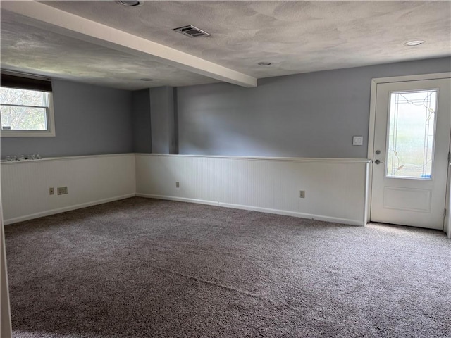 27 Brook St, West Warwick, RI 02893 - carpeted empty room with a wainscoted wall, beamed ceiling, and a textured ceiling