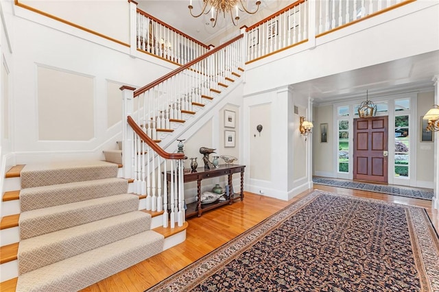 15 Courageous Cir, Bristol, RI 02809 - entryway with a chandelier, stairway, wood finished floors, a towering ceiling, and ornamental molding