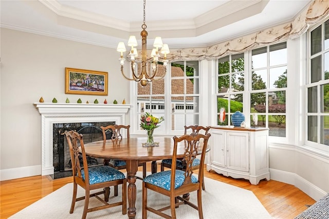 15 Courageous Cir, Bristol, RI 02809 - dining area with a tray ceiling, light wood-style flooring, crown molding, a chandelier, and a fireplace