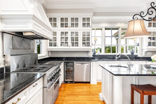 15 Courageous Cir, Bristol, RI 02809 - kitchen featuring stainless steel appliances, beverage cooler, custom range hood, white cabinetry, and ornamental molding