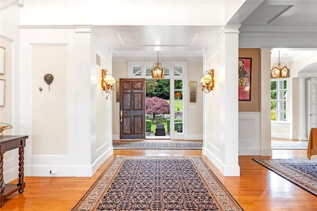 15 Courageous Cir, Bristol, RI 02809 - foyer featuring light wood-type flooring, decorative columns, a decorative wall, crown molding, and a wainscoted wall