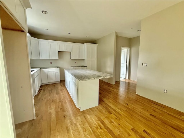 94 Ashaway Rd, Westerly, RI 02891 - kitchen featuring white cabinets, light wood-type flooring, a center island, light stone countertops, and recessed lighting
