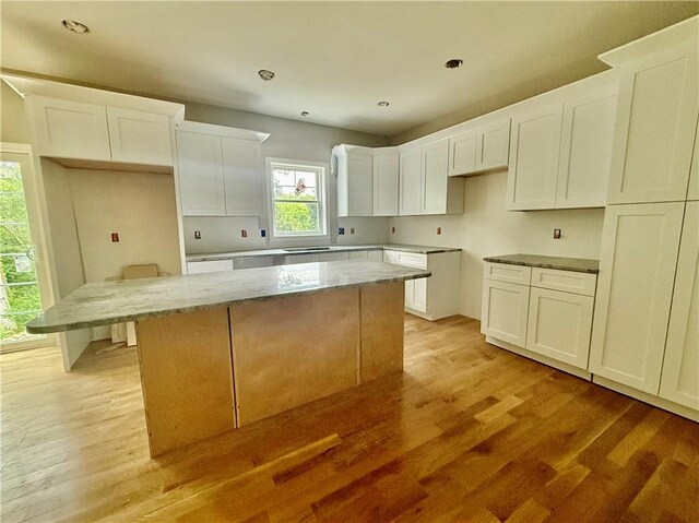 94 Ashaway Rd, Westerly, RI 02891 - kitchen with a kitchen island, light wood-type flooring, white cabinets, light stone counters, and recessed lighting