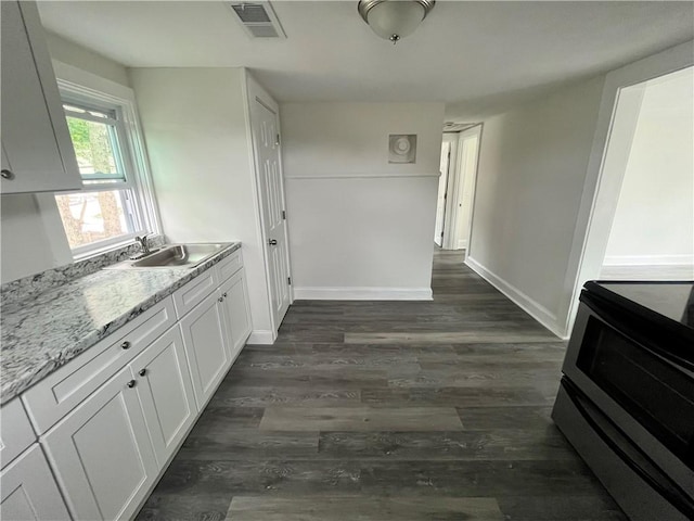 22 Agnes St, West Warwick, RI 02893 - kitchen with electric stove, white cabinetry, dark wood-style floors, and light stone counters