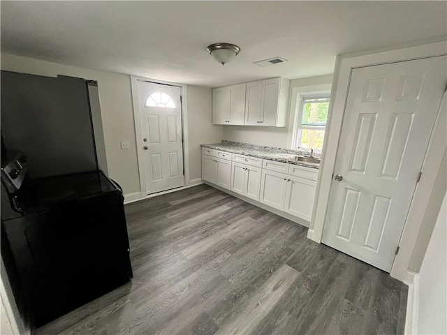 22 Agnes St, West Warwick, RI 02893 - kitchen featuring stove, white cabinetry, dark wood finished floors, and freestanding refrigerator
