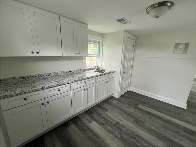 22 Agnes St, West Warwick, RI 02893 - kitchen with dark wood-style flooring, white cabinets, and light stone countertops