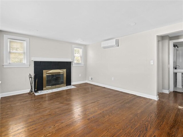 10 Palmer St, Smithfield, RI 02828 - unfurnished living room with a wall mounted air conditioner, a fireplace with flush hearth, and wood finished floors
