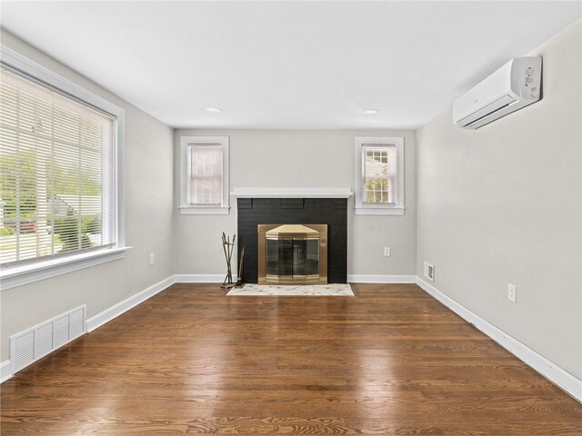 10 Palmer St, Smithfield, RI 02828 - unfurnished living room with an AC wall unit, a fireplace, and wood finished floors