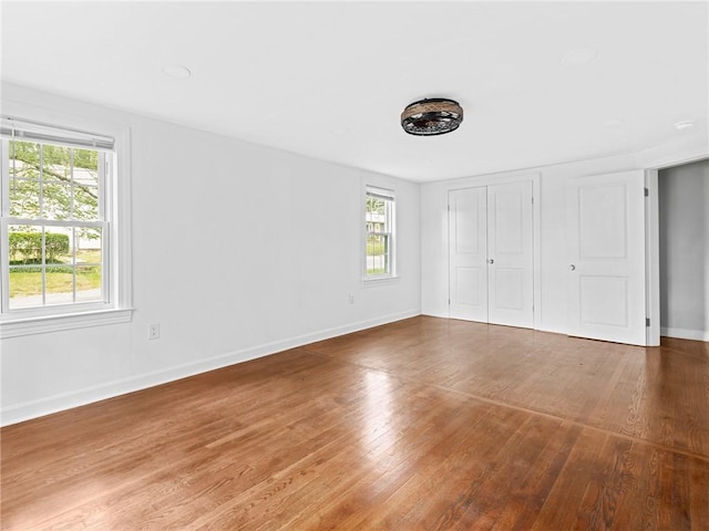 10 Palmer St, Smithfield, RI 02828 - unfurnished bedroom with multiple windows, wood finished floors, and a closet