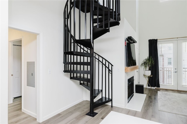 1000 Providence Pl Unit 467, Providence, RI 02903 - stairway featuring wood finished floors, electric panel, a fireplace, and a towering ceiling