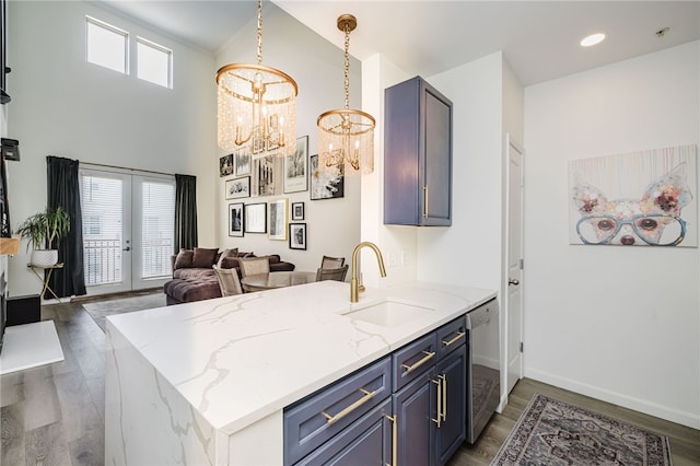 1000 Providence Pl Unit 467, Providence, RI 02903 - kitchen with stainless steel dishwasher, a chandelier, wood finished floors, light stone countertops, and a peninsula