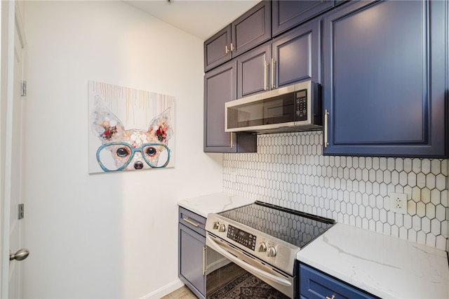 1000 Providence Pl Unit 467, Providence, RI 02903 - kitchen featuring appliances with stainless steel finishes, decorative backsplash, light stone counters, and blue cabinetry