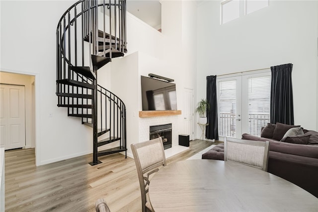 1000 Providence Pl Unit 467, Providence, RI 02903 - dining space with a towering ceiling, light wood finished floors, a glass covered fireplace, stairs, and french doors