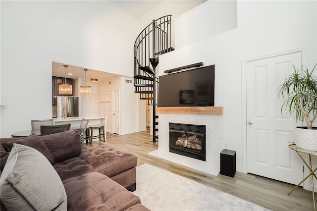 1000 Providence Pl Unit 467, Providence, RI 02903 - living area featuring light wood-style floors, a towering ceiling, stairway, and a glass covered fireplace