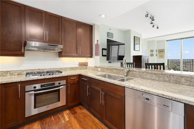 1 W Exchange St Unit 2802, Providence, RI 02903 - kitchen with appliances with stainless steel finishes, under cabinet range hood, wood finished floors, light stone countertops, and rail lighting
