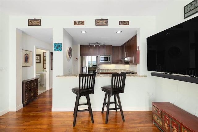1 W Exchange St Unit 2802, Providence, RI 02903 - kitchen with stainless steel appliances, a peninsula, wood finished floors, a kitchen breakfast bar, and dark brown cabinetry