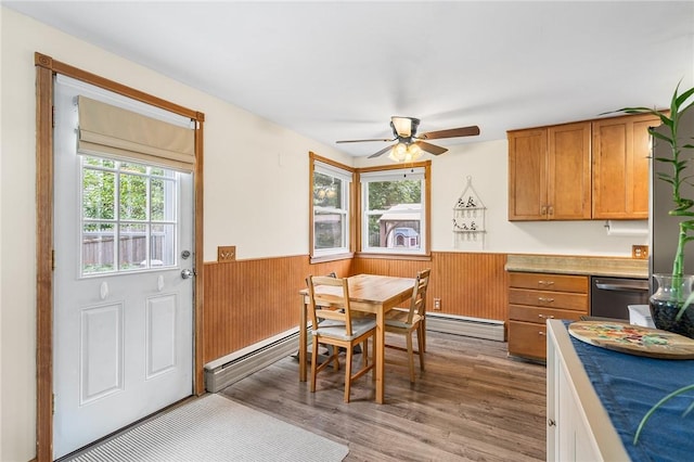62 Pembroke Ln, Coventry, RI 02816 - dining room with a baseboard radiator, a wainscoted wall, ceiling fan, wood finished floors, and wooden walls