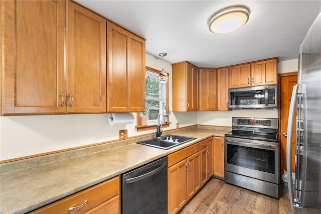 62 Pembroke Ln, Coventry, RI 02816 - kitchen featuring stainless steel appliances, light wood finished floors, brown cabinetry, and light countertops