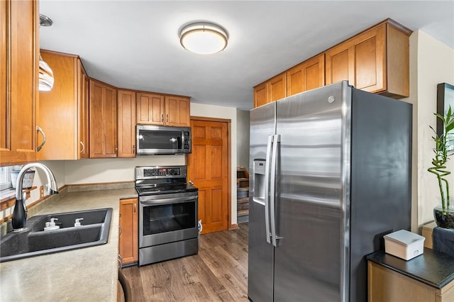 62 Pembroke Ln, Coventry, RI 02816 - kitchen featuring appliances with stainless steel finishes, light wood finished floors, brown cabinetry, and light countertops