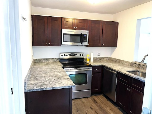 84 Tell St Unit 4A, Providence, RI 02909 - kitchen featuring appliances with stainless steel finishes, dark wood finished floors, dark brown cabinets, and a peninsula