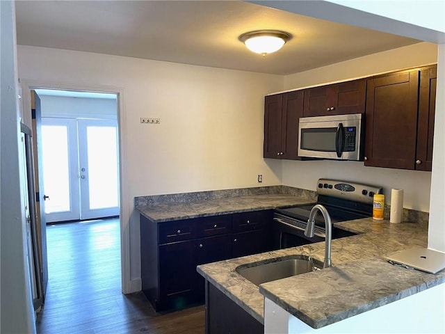 84 Tell St Unit 4A, Providence, RI 02909 - kitchen with stainless steel appliances, dark brown cabinets, dark wood-style floors, a peninsula, and dark stone countertops