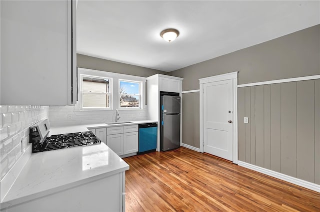 15 Melissa St, Providence, RI 02909 - kitchen with appliances with stainless steel finishes, decorative backsplash, light wood-style floors, light stone countertops, and white cabinetry
