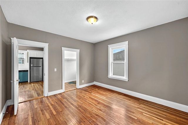 15 Melissa St, Providence, RI 02909 - unfurnished bedroom with freestanding refrigerator, light wood finished floors, a closet, and multiple windows