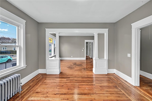 15 Melissa St, Providence, RI 02909 - unfurnished room featuring radiator, decorative columns, and light wood-style floors