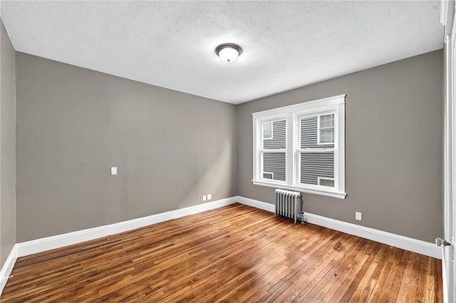 15 Melissa St, Providence, RI 02909 - spare room featuring radiator heating unit, wood-type flooring, and a textured ceiling